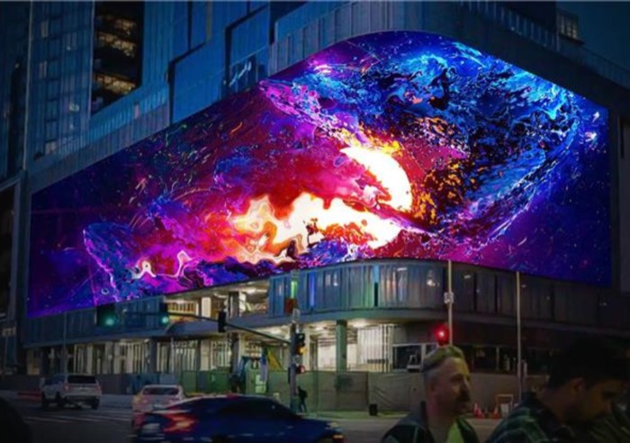 Curved LED façade lighting a city corner at night